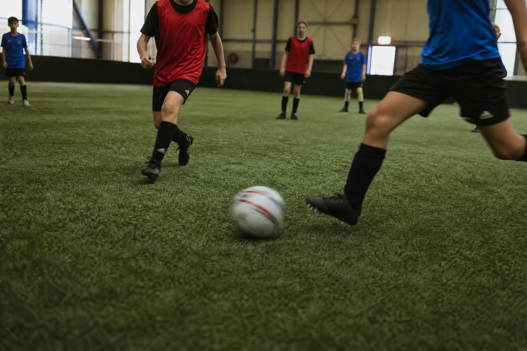 Kids playing indoor five-a-side football at a birthday party