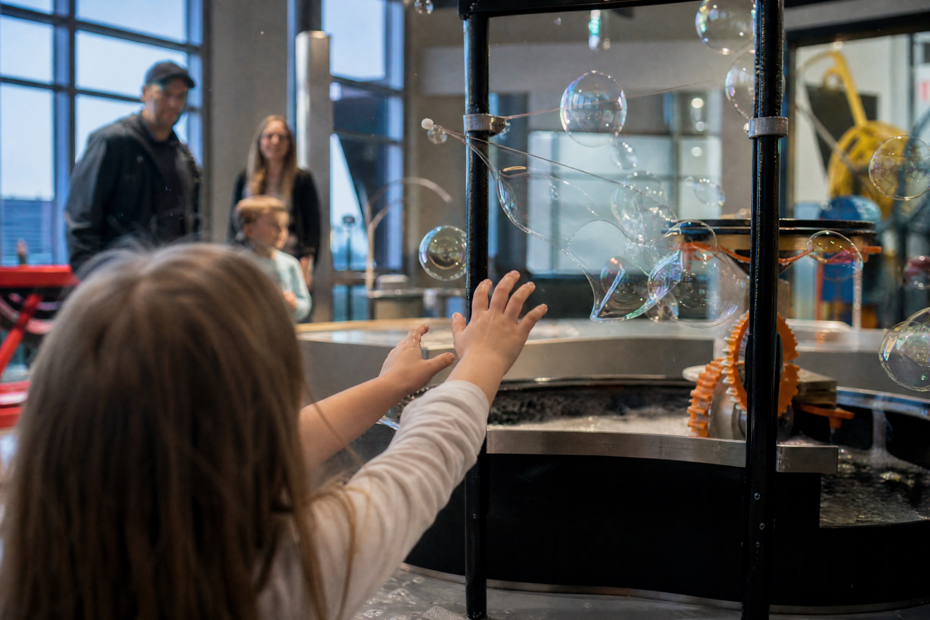 Child touching an interactive science exhibit at NEMO Science Museum with kids