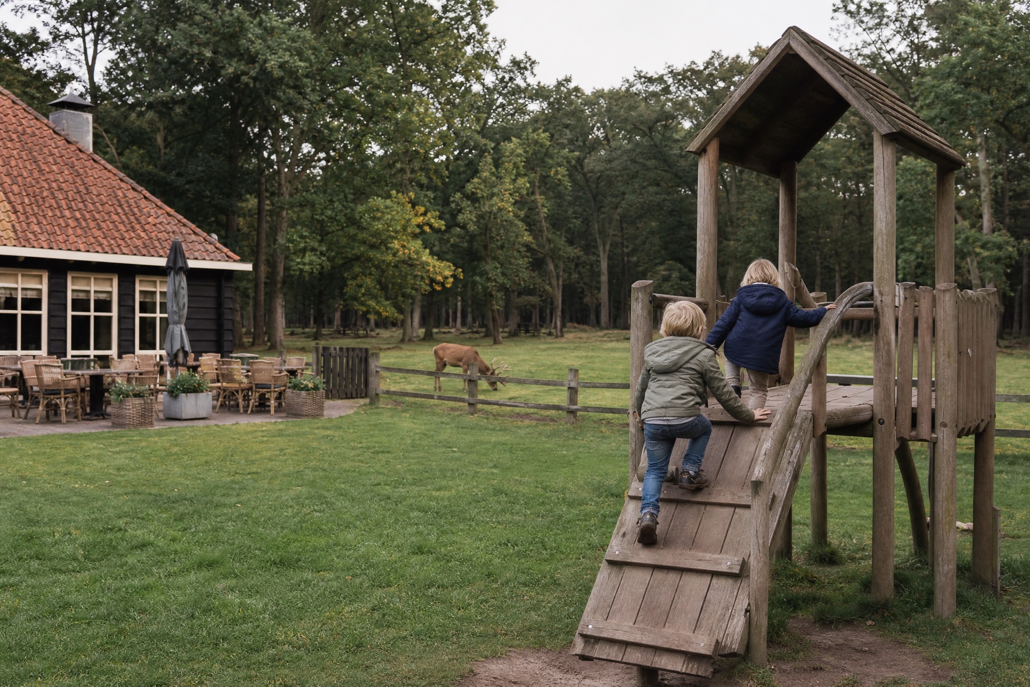 Kids climbing a wooden playset with a deer grazing nearby at a pancake farm near Amsterdam