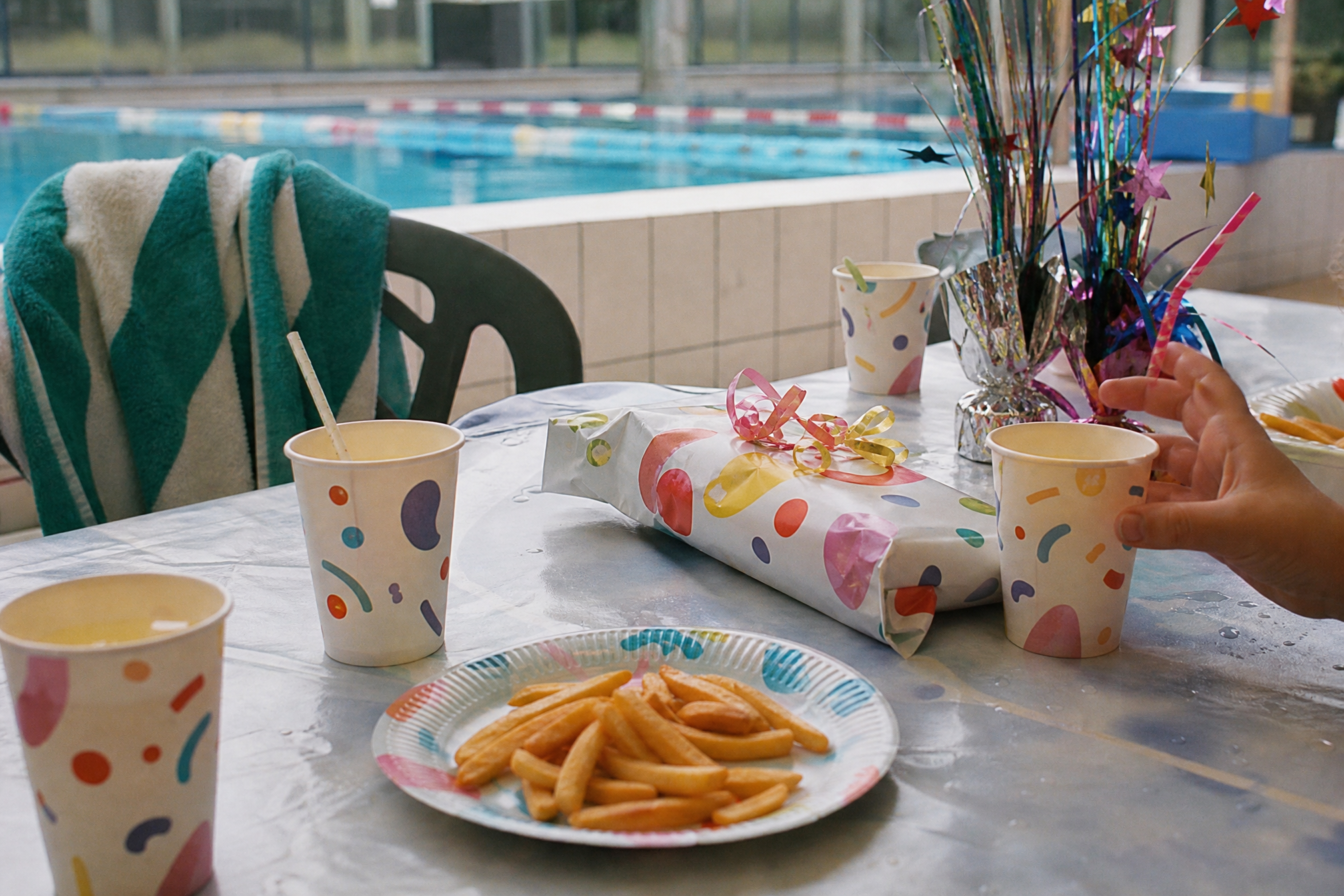 Poolside birthday party table with lemonade, fries and a wrapped present at a Dutch swimming pool
