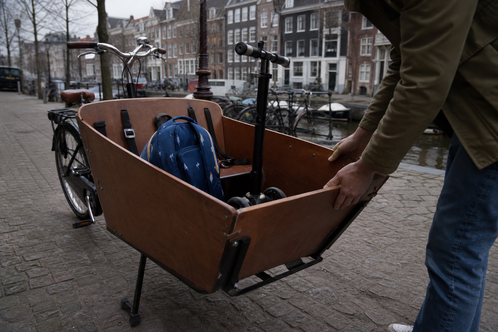 Dutch cargo bike bakfiets loaded with a backpack, cycling with kids setup