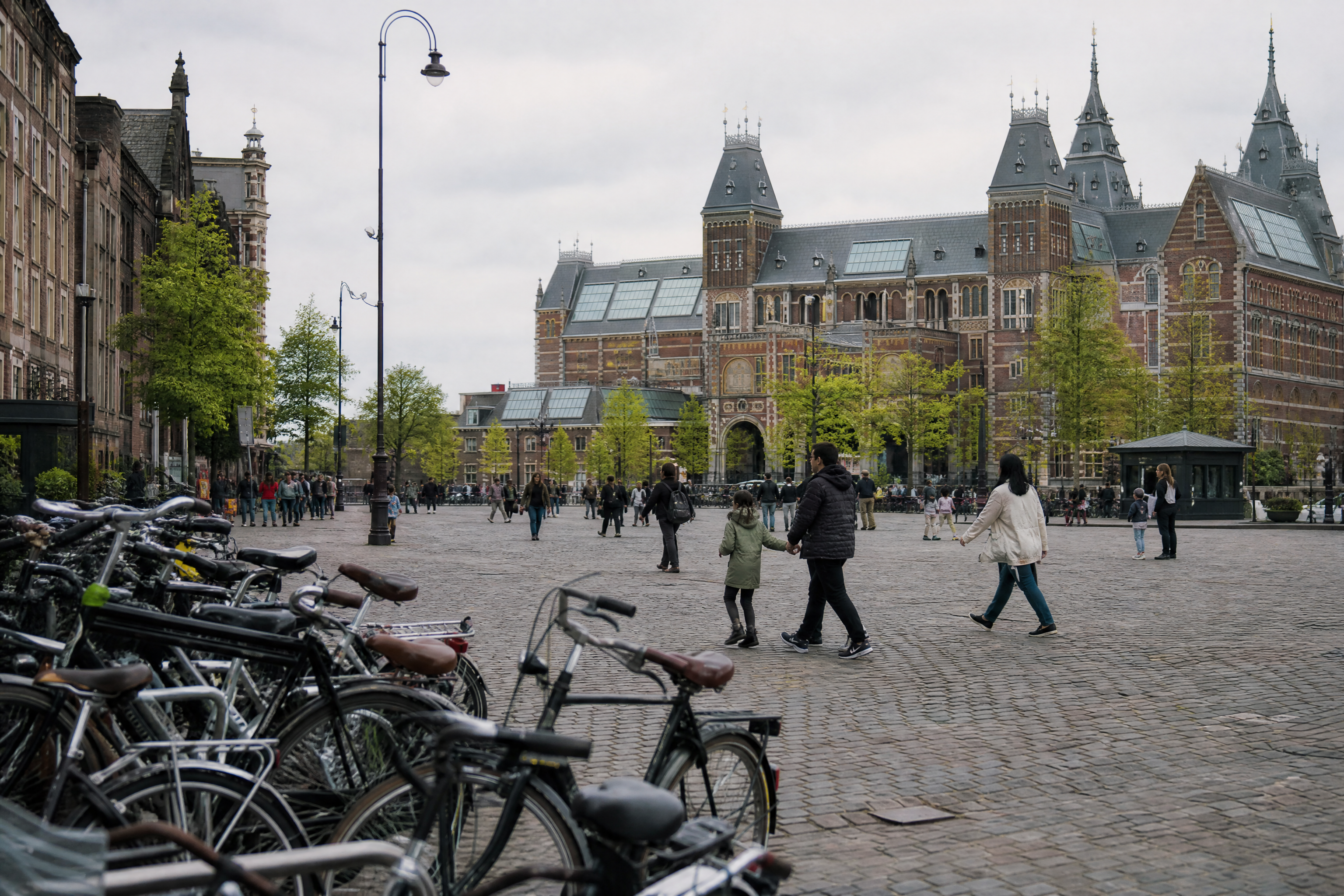 Family with bicycles near a historic Amsterdam museum during a free museum discount day