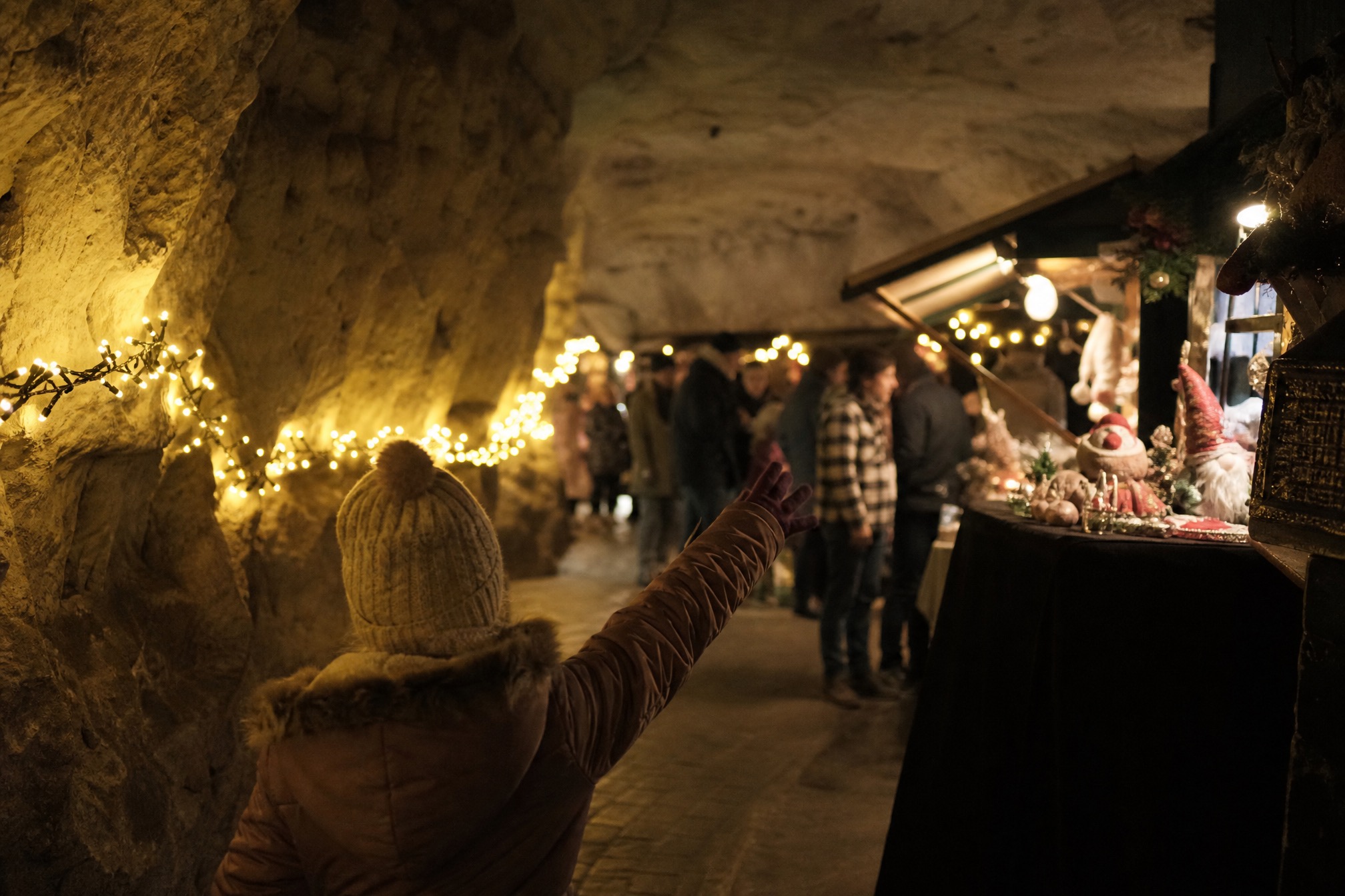 Child looking at a stall inside the underground Christmas market caves in Valkenburg