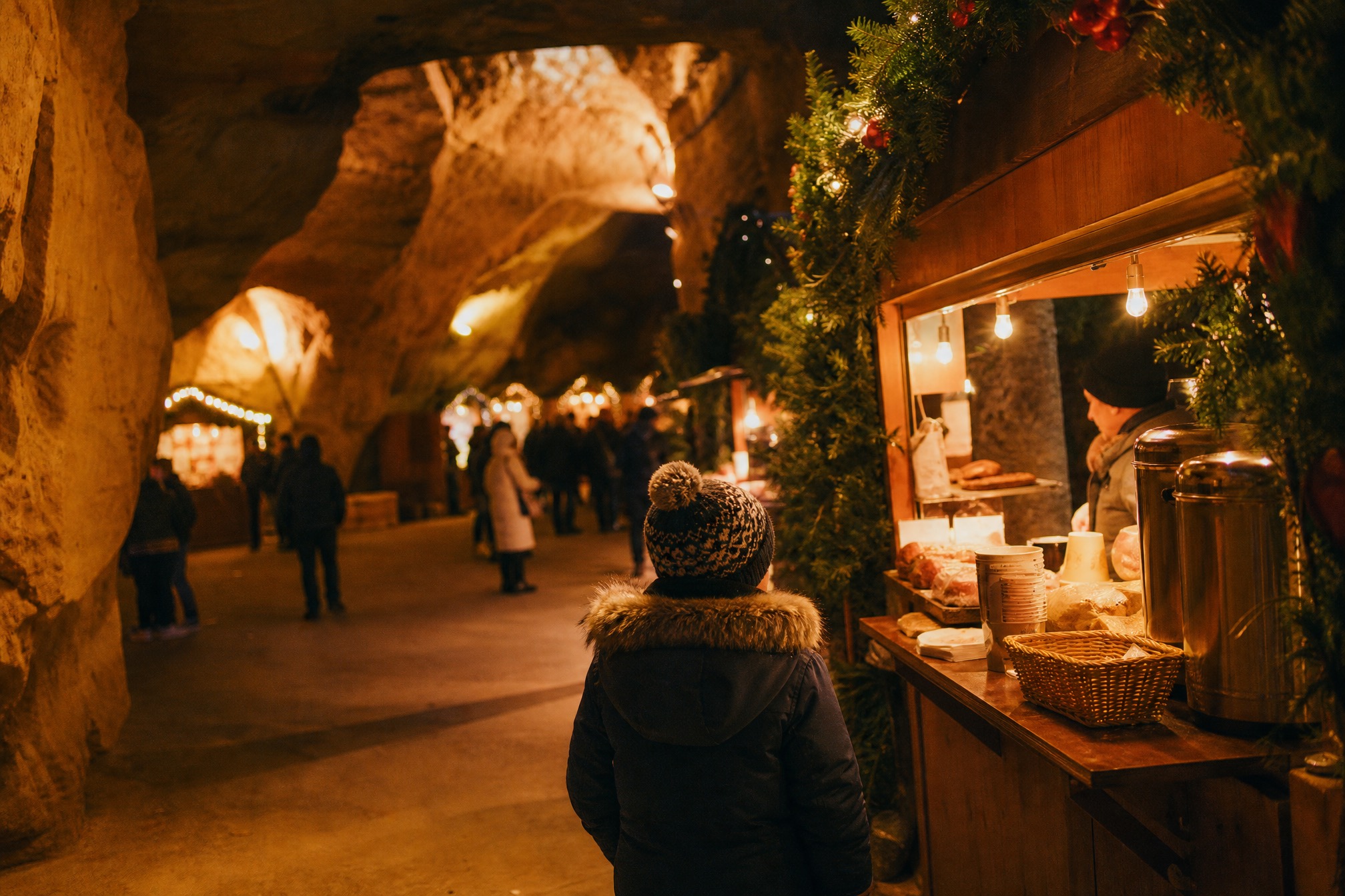 Child looking at a stall inside the underground cave Christmas market in Valkenburg