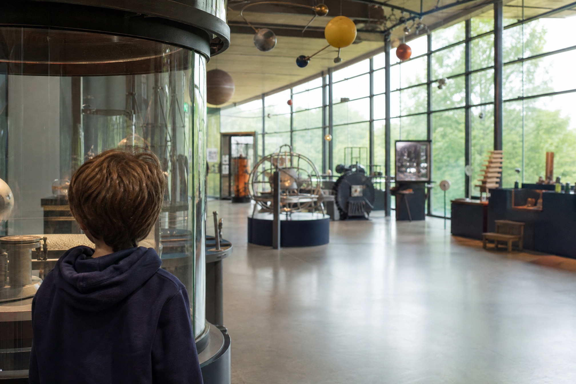 Child exploring a calm, uncrowded science museum hall during a quiet weekday morning visit
