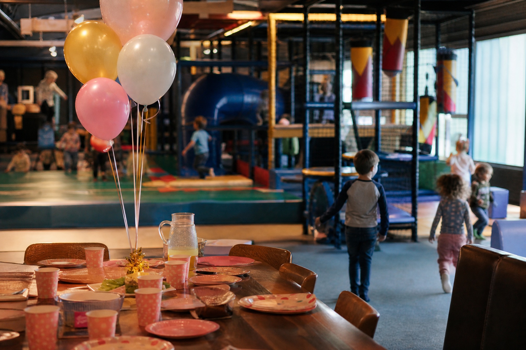 Indoor playground birthday party table with balloons in Amsterdam